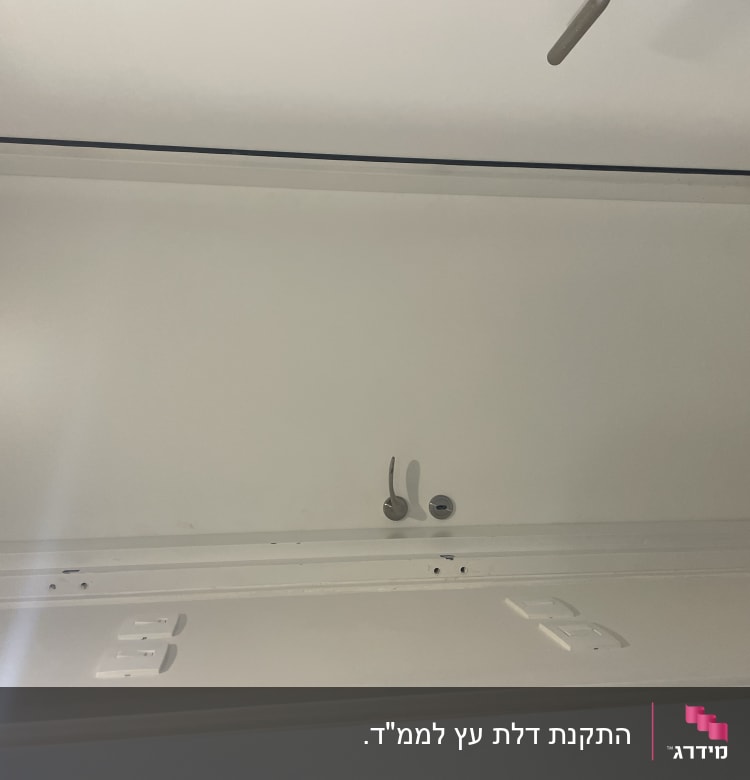 דלת לבנה עם ידית מתכת ומנעול עגול